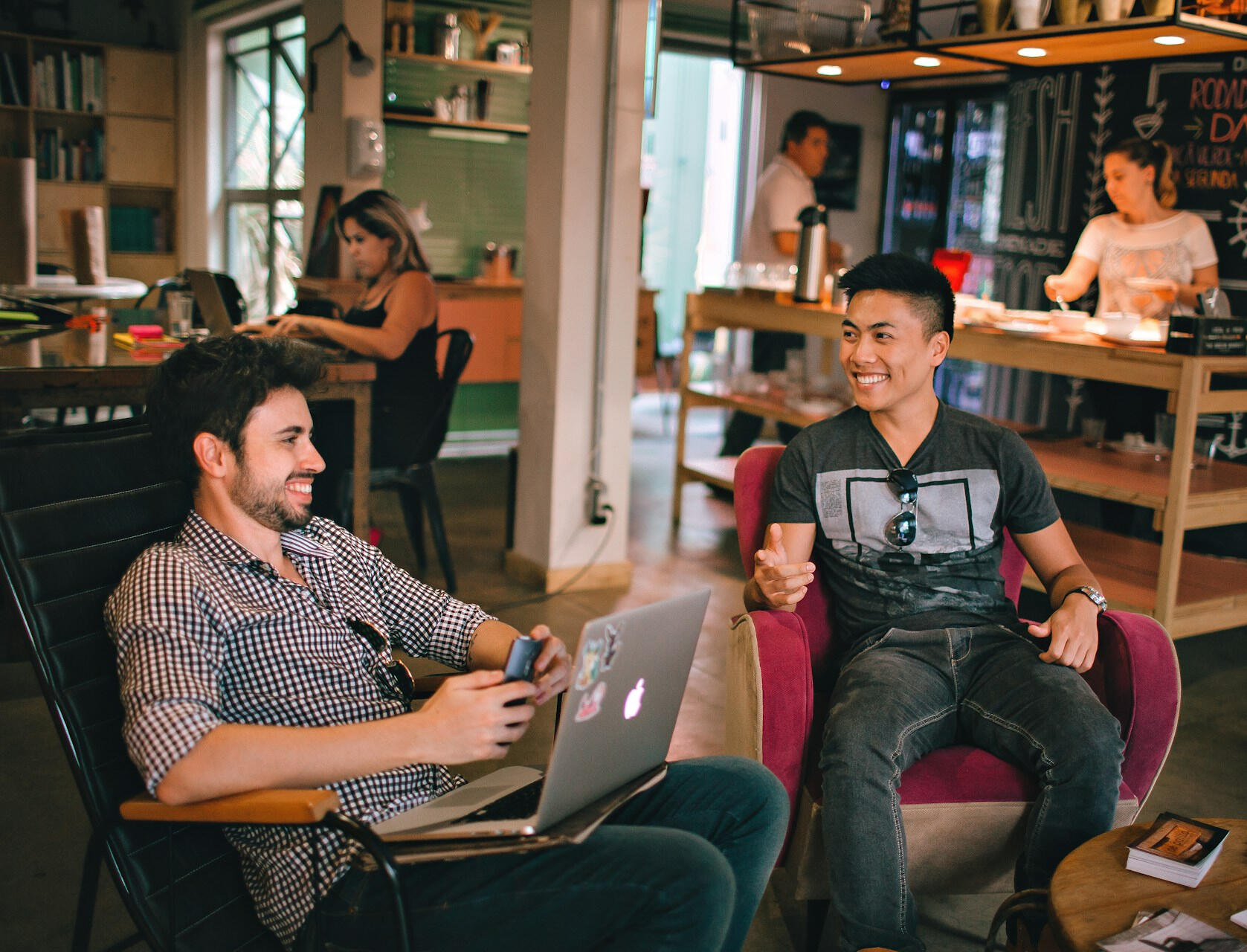 Two smiling men in a coffee shop